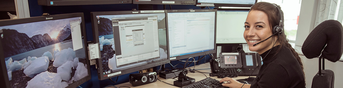 En medarbetare arbetar framför flera datorskärmar. 