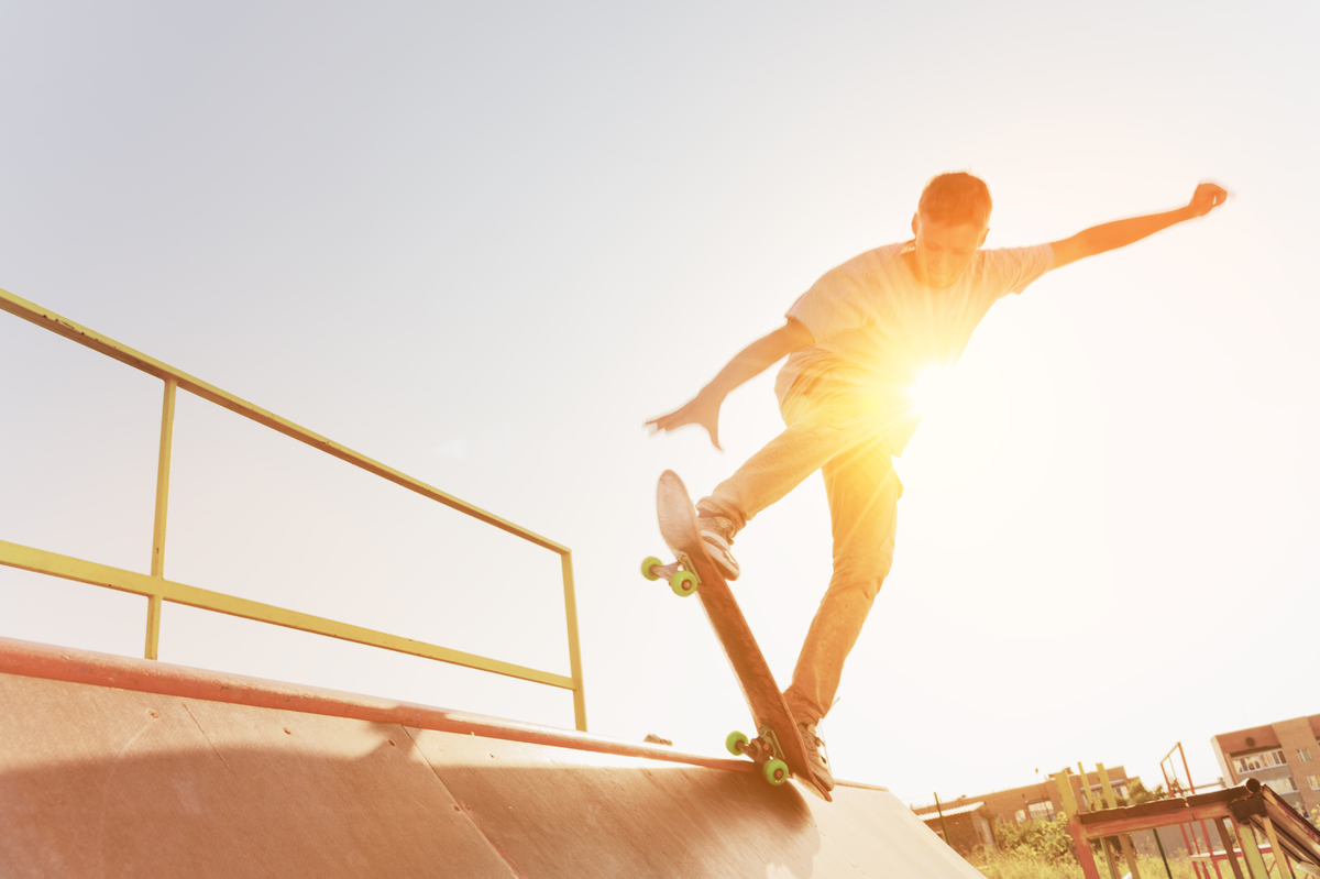 mp22957656-teen-skater-hang-up-over-a-ramp-on-a-skateboard-in-a-skate-park.jpg