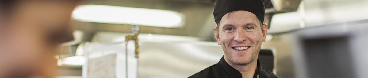 Leende man i storkök