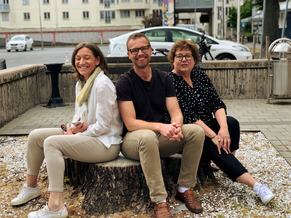 Tre kollegor från Bergenstråhle & Partners sitter tillsammans på en stubbe