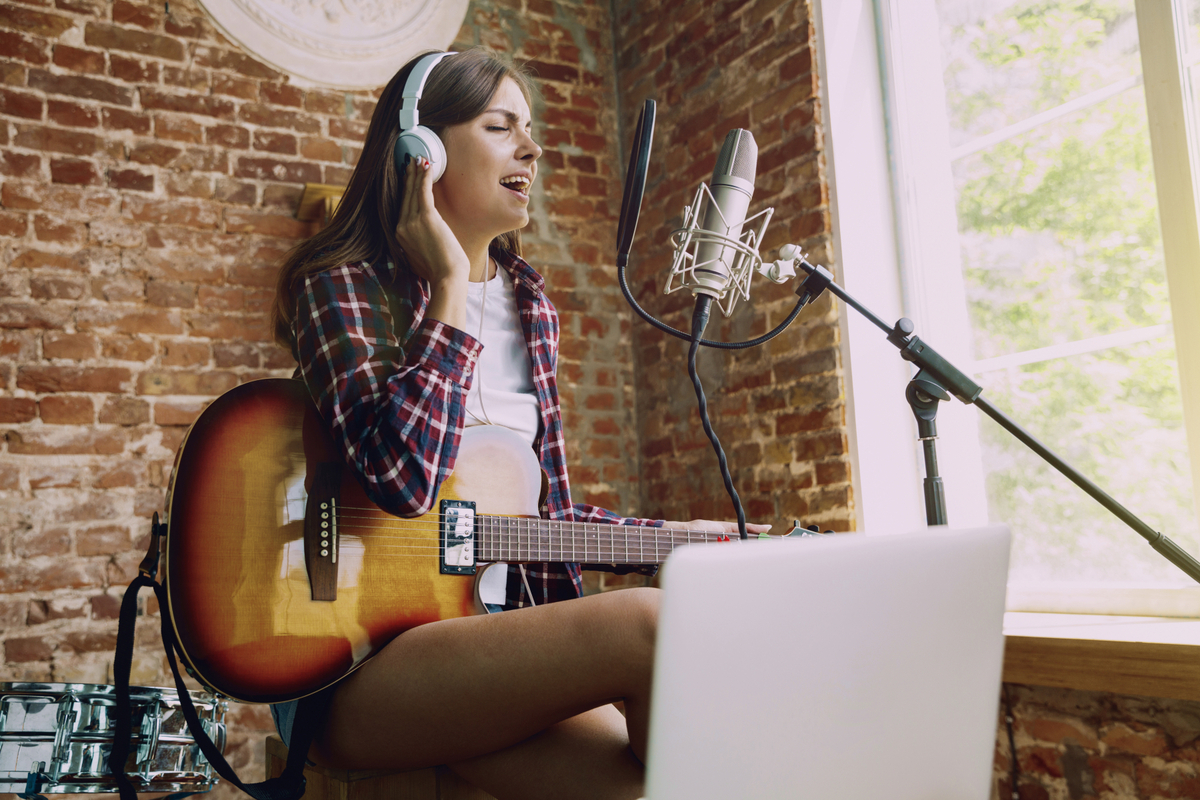 32588545-woman-recording-music-playing-guitar-and-singing-at-home.jpg