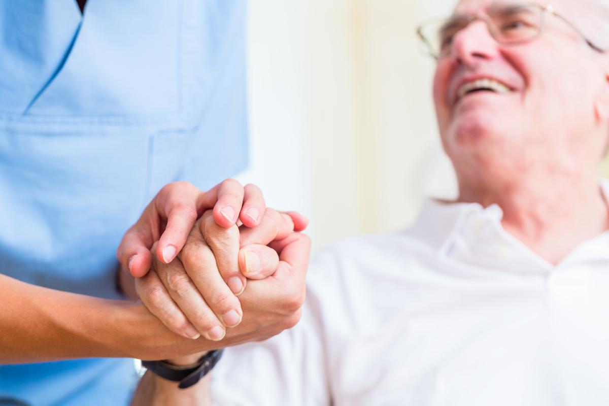 mp16282351-nurse-holding-hand-of-senior-man-in-rest-home.jpg