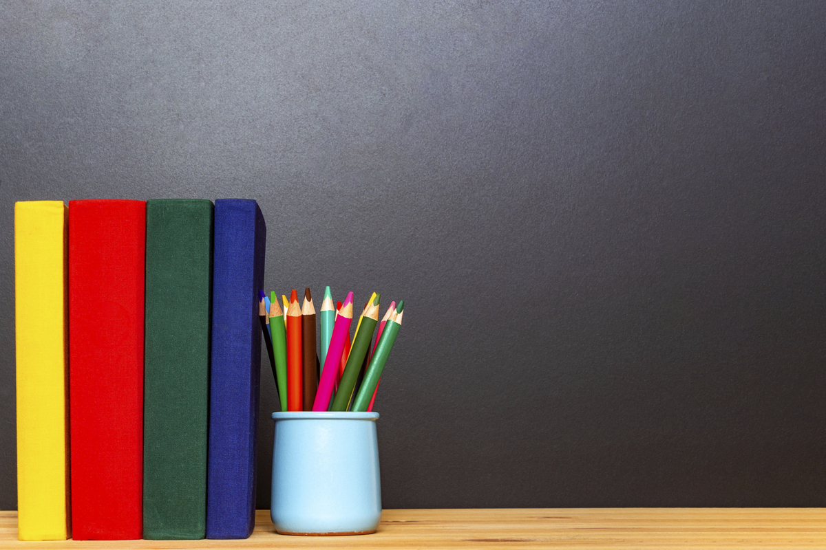 Färgglada böcker och pennor på ett skrivbord