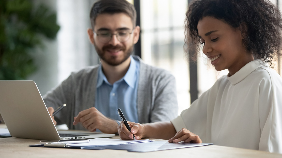 49791792-smiling-ethnic-female-employee-sign-document-at-meeting.jpg