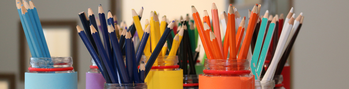 Färggranna pennor i olika burkar