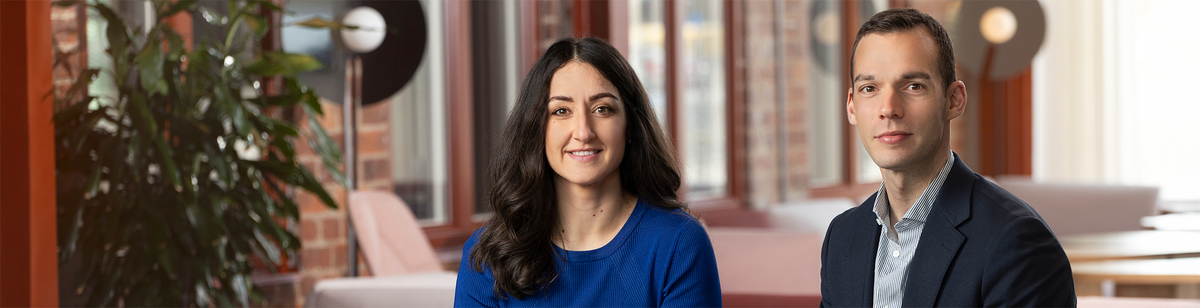 En kvinnlig kollega i samspråk med en manlig kollega sittandes i entrén.jpg