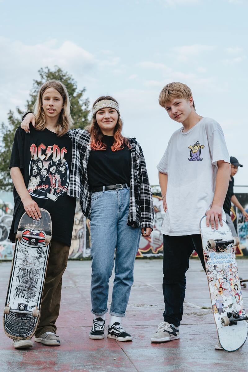 Tre ungdomar som poserar med sina skateboards. 